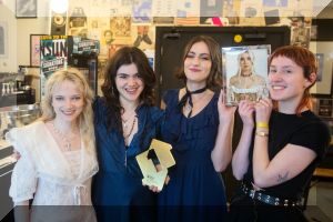 The Last Dinner Party pictured with their Official Number 1 award as they celebrate their debut Number 1 album Prelude to Ecstasy (Credit: Official Charts) 